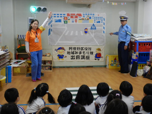 横断歩道の絵図を使って安全なわたり方を説明する警察官