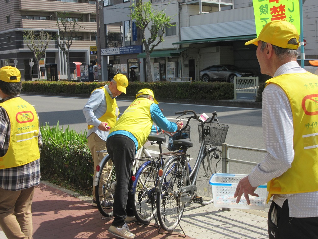 西田辺駅周辺の放置自転車に啓発札を取り付けるサイクルサポーターの皆さま