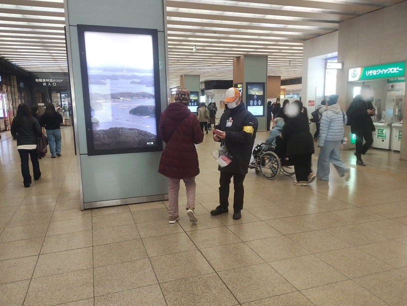 駅利用者に啓発物品を配付して注意喚起する区役所職員