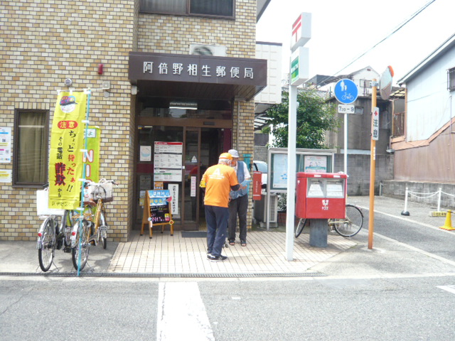 阿倍野相生郵便局前で利用者に特殊詐欺被害防止を呼びかける区役所職員