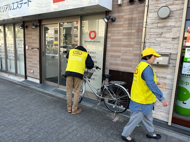 西田辺駅周辺の放置自転車に啓発札を取りつけるサイクルサポーター