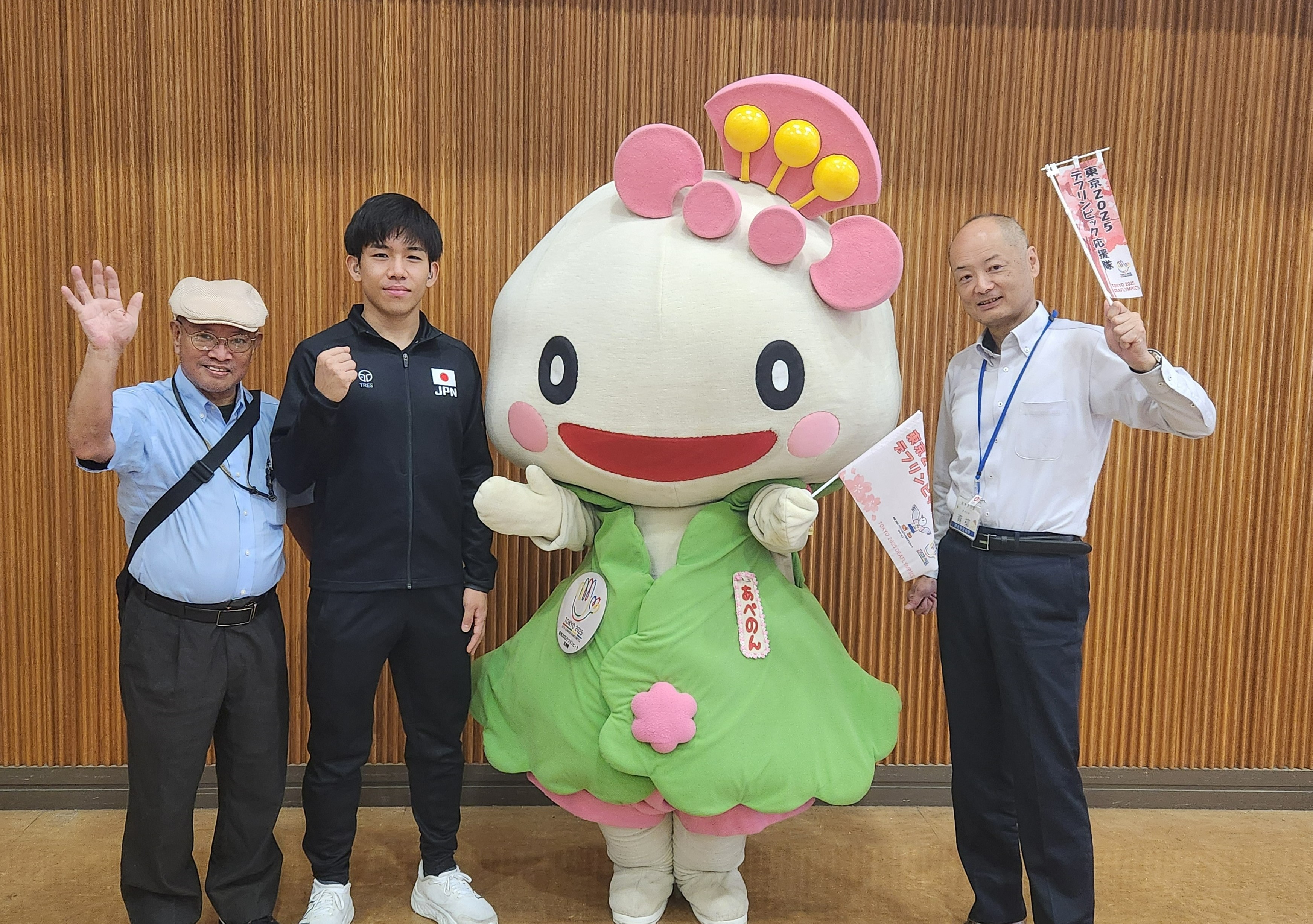 左から、阿倍野区身体障がい者団体協議会の梅本会長、坂下選手、あべのん、青柳阿倍野区長が並んでいる写真。デフリンピックPRの旗を持っている。