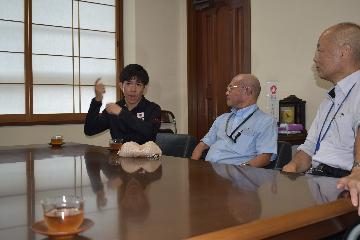 区長室で着席してお話している様子。坂下選手と阿倍野区身体障がい者団体協議会の梅本会長、青柳区長。坂下選手が手話をしている。