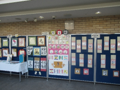 絵手紙と書道の作品がパネルと机に展示されている様子