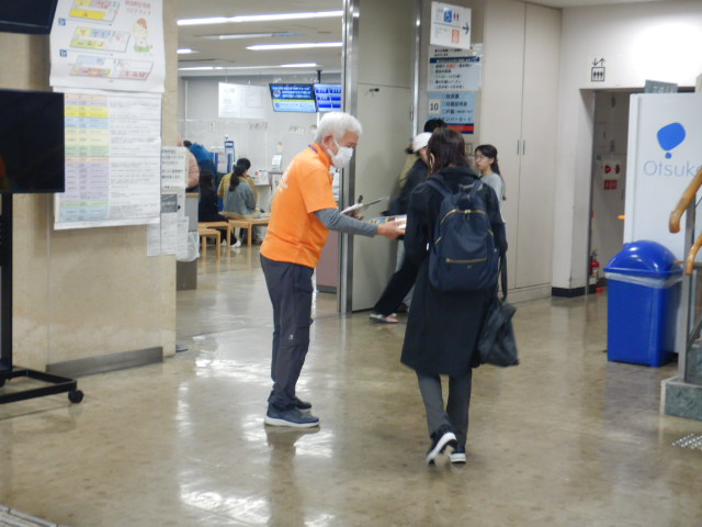 来庁者に啓発物品を配付して注意喚起する区役所職員