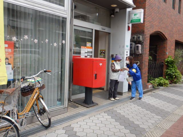 郵便局前で利用者に注意喚起する区役所職員