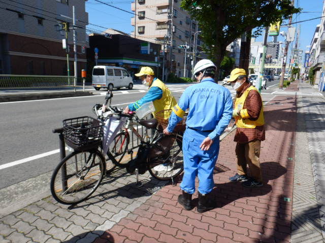 西田辺駅周辺の放置自転車に啓発札を取りつけるサイクルサポーター
