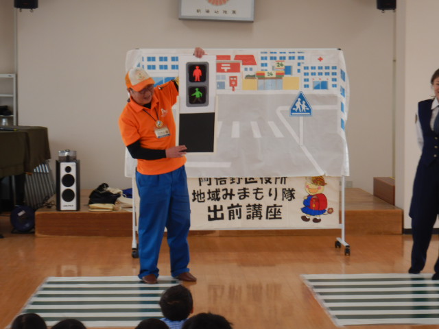 歩行者信号の説明をする区役所職員
