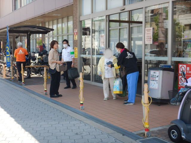 利用者に啓発物品を配付して注意喚起する区役所職員