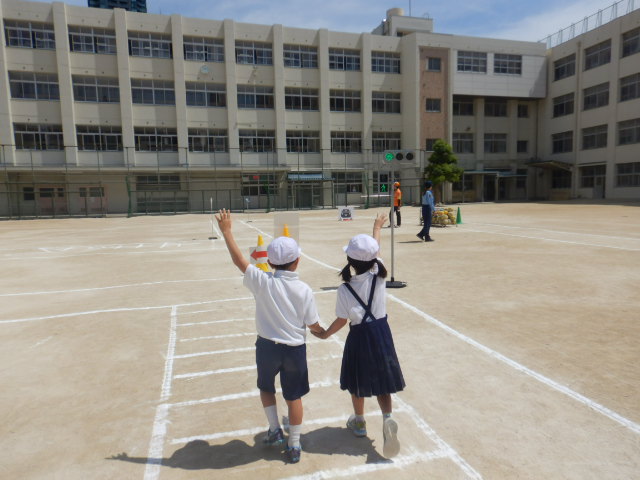 運動場に描いた横断歩道を安全にわたる児童