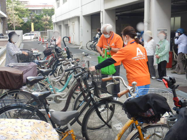 キャンペーン参加者の自転車前かごに啓発物品を配付する区役所職員