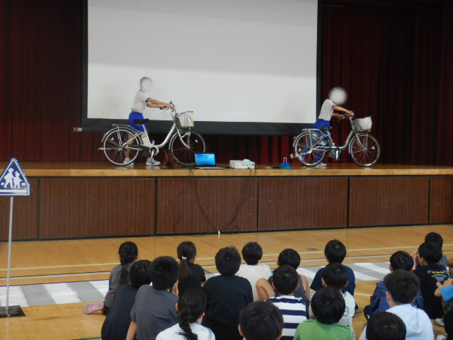 舞台上で自転車の点検の仕方を中学生がおこなう。