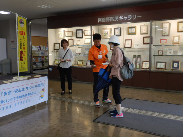 来庁者に啓発物品を配付して注意喚起する区役所職員