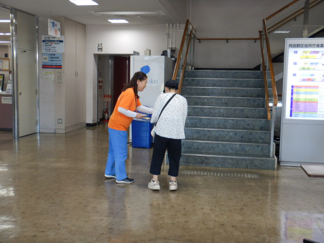 来庁者に特殊詐欺の電話に気をつけてくださいと注意喚起する区役所職員