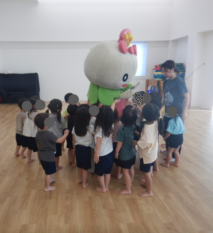 あべのんを囲んでタッチや抱き着く園児たち
