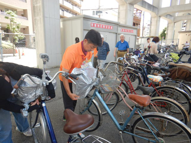 キャンペーン参加者の自転車前かごにひったくり防止カバーを取りつける