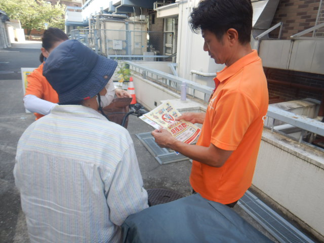 キャンペーン参加者に啓発物品を配付し注意喚起する区役所職員