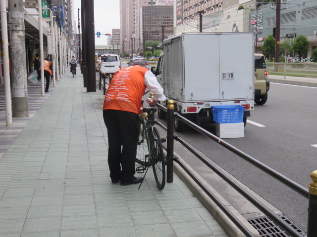 歩道上の放置自転車に啓発札を取りつける