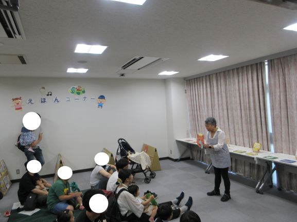 たくさんの子どもたちが座って絵本に見入っている写真