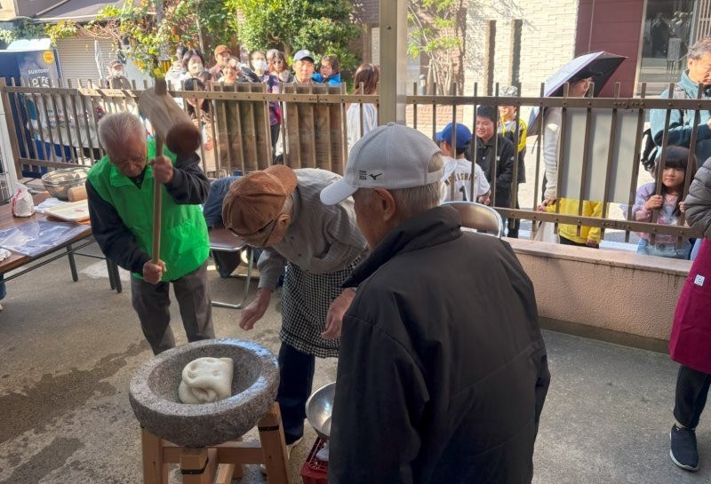 列に並んだ人達は、餅つきの様子を見学していました。