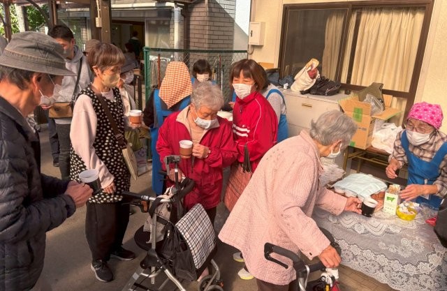ふるまいコーヒーを受け取る来場者たち
