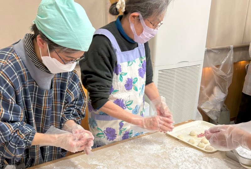 つきたてのお餅を手早く丸めます。