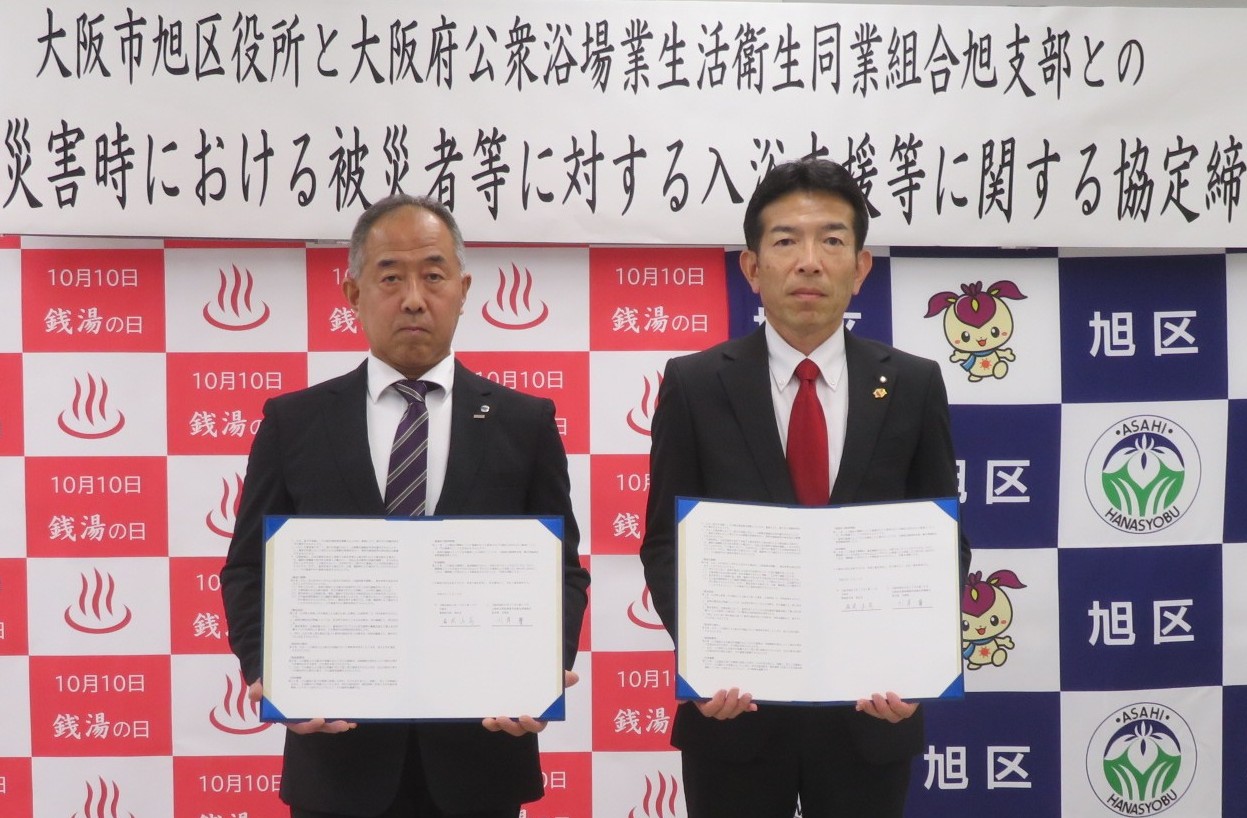 協定書を持っている大阪府公衆浴場業生活衛生同業組合川岸支部長様と旭区役所福岡区長