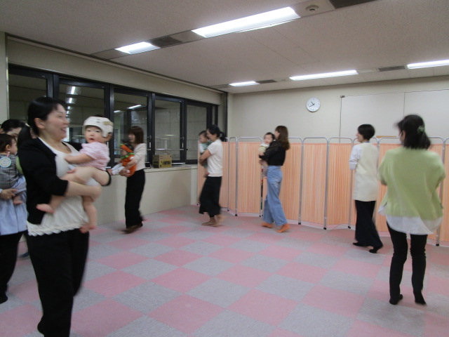 保護者のか方がお子さんを抱いて音楽に合わせて歩いている様子