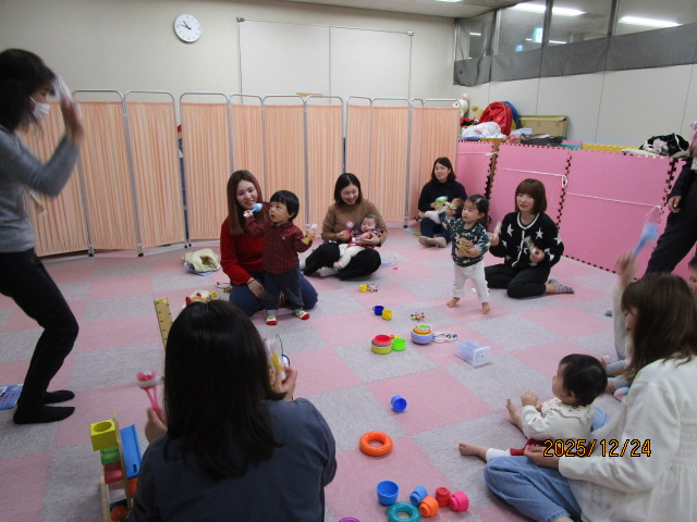 親子で音楽に合わせて手作り楽器を鳴らしている様子