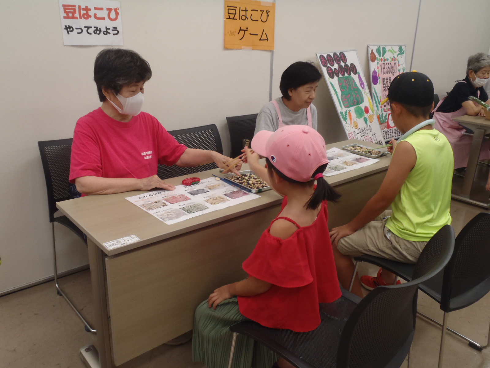 昨年の食育なつまつりで子どもが豆はこびゲームをしている写真