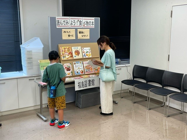 食育の本の展示を親子が見ている写真