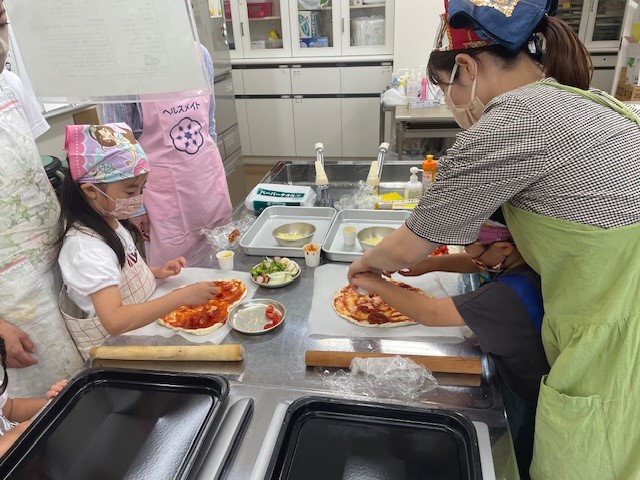 昨年のおやこの食育教室で親子がピザを調理している写真
