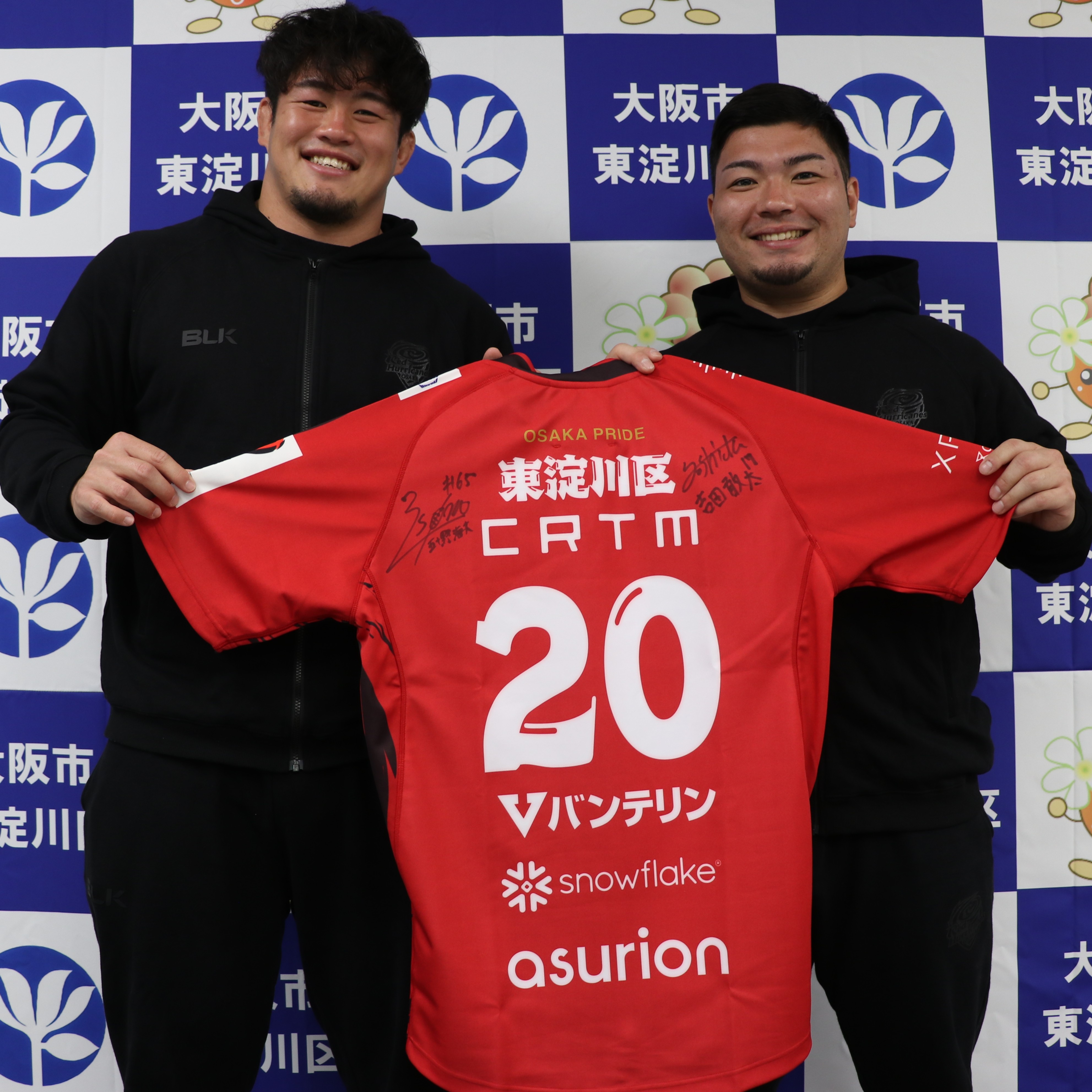 サイン入りユニフォームを持つレッドハリケーンズ大阪の選手