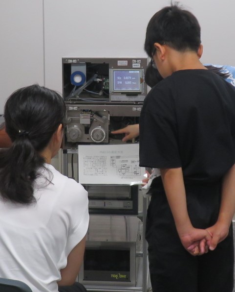 大気汚染物質を測定する機械を観察している様子