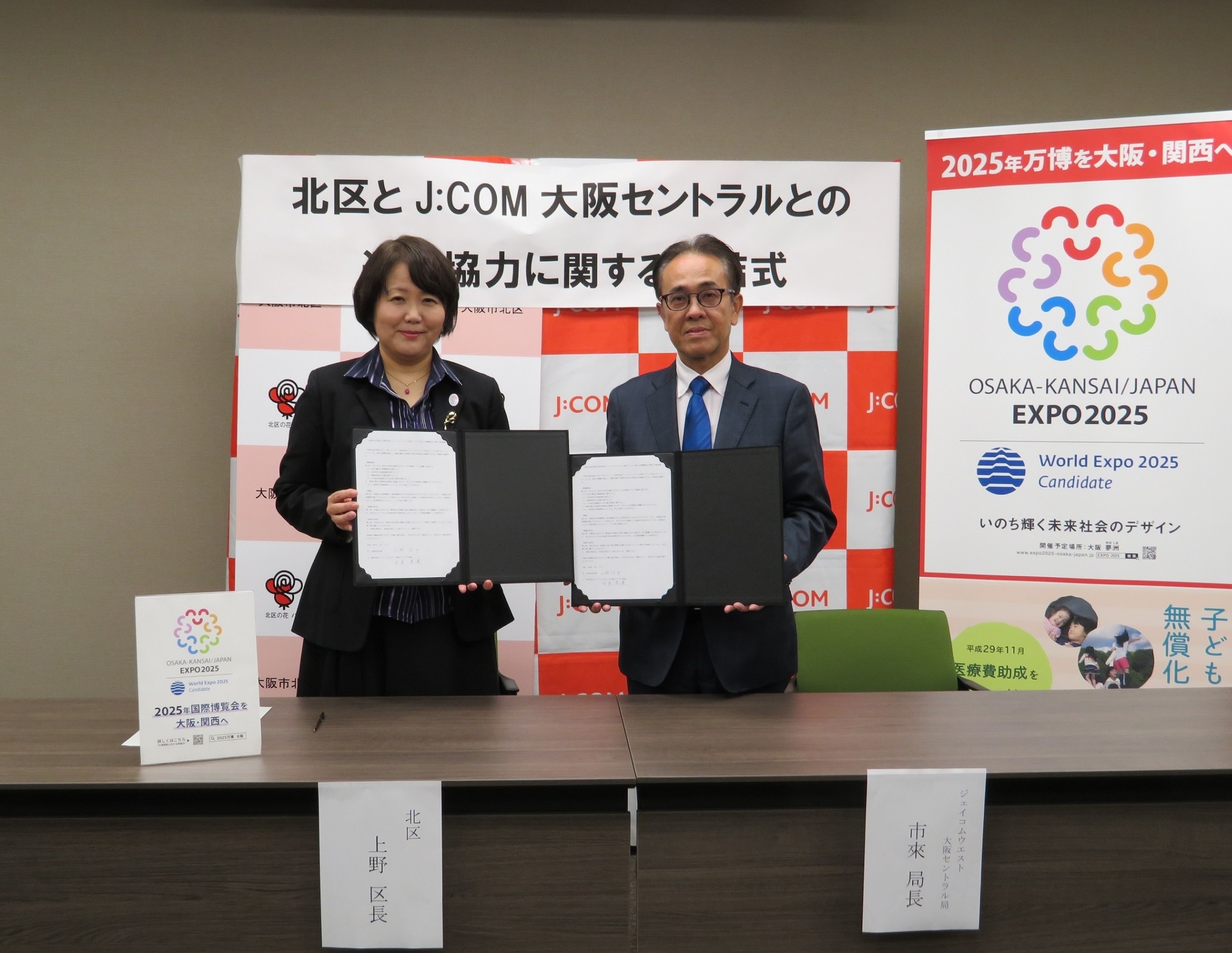 協定書を手に並ぶ上野区長と市來（いちき）局長
