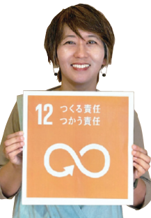 実行委員会の中川美陽子さんがSDGsの12番のボードを持っている写真