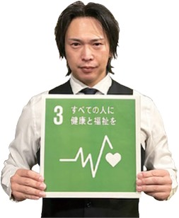 オーナーの谷島雄一郎さんがSDGsの3番のボードを持っている写真