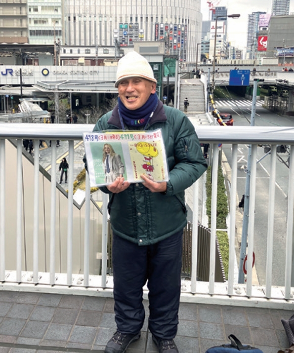 梅田の歩道橋で販売者がビッグイシューを売っている様子