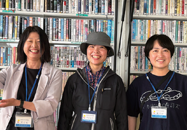 本棚の前に並ぶ3人の司書