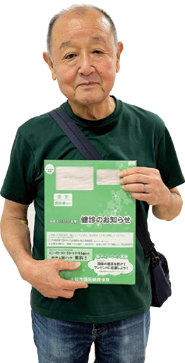 緑の封筒に入った受診券を持つ区民