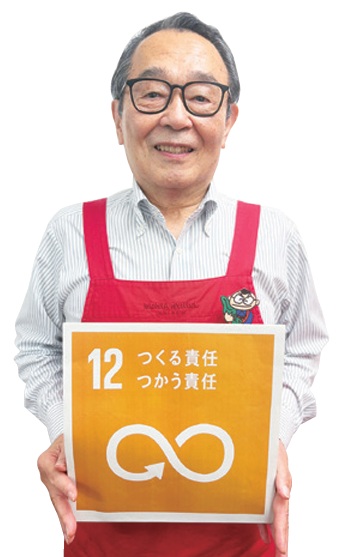 代表取締役の喜多條清光さんがSDGsの12番のボードを持っている写真
