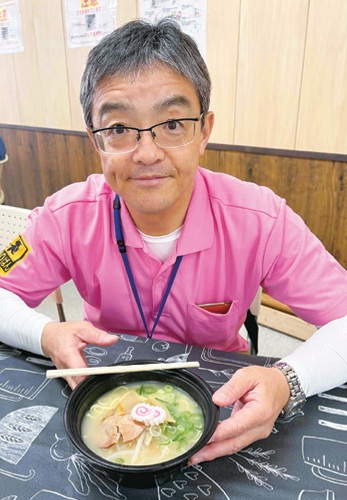 寺本区長がふれあい喫茶で提供されたラーメンを持っている様子