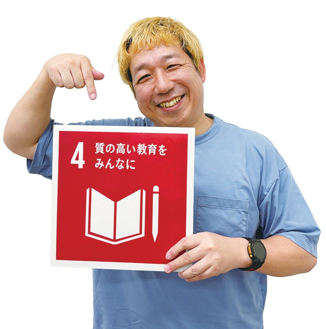 広報部制作課課長の増田誠司さんがSDGsの4番のボードを持っている写真