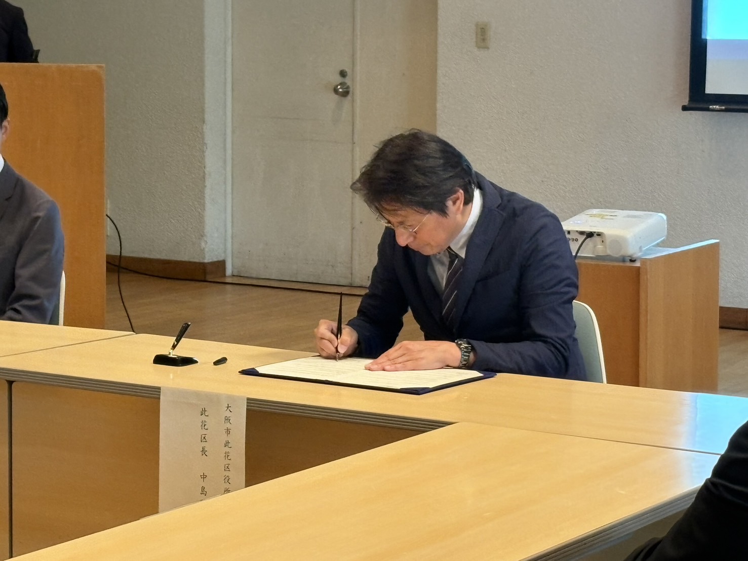 連携協定書に署名している様子の写真