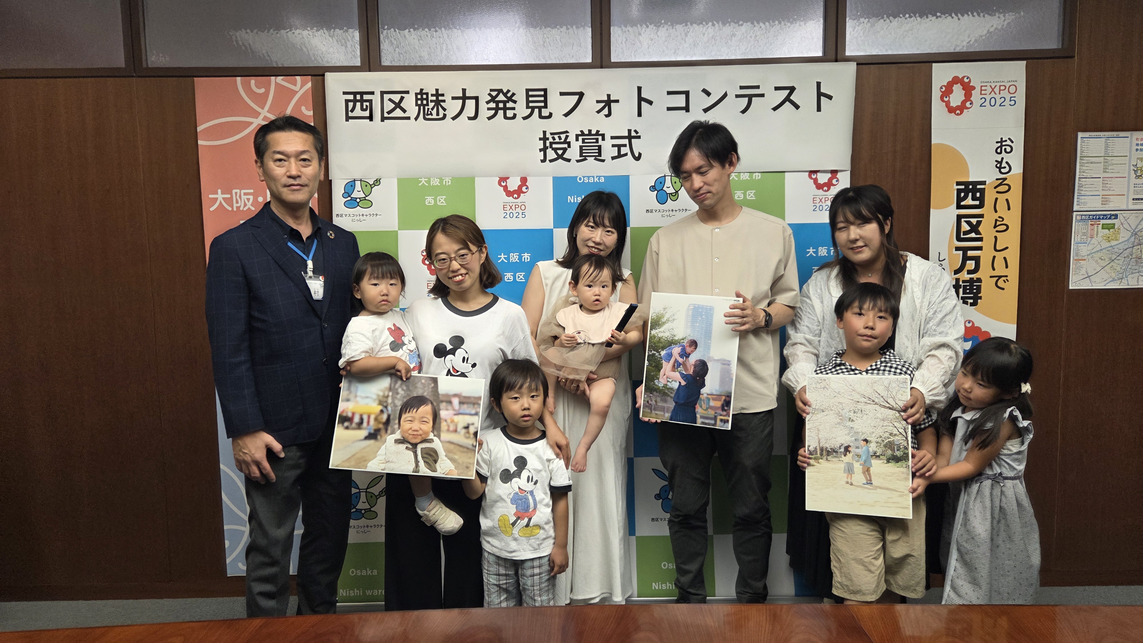 西区長と受賞者。選ばれた作品のパネルを持っている。