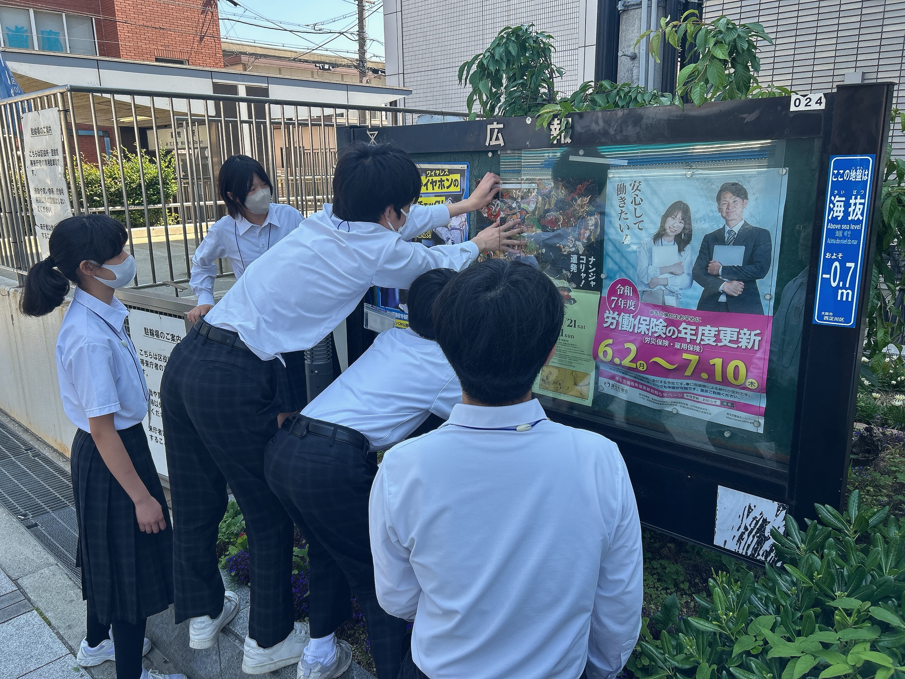 広報掲示板にポスターを貼る様子