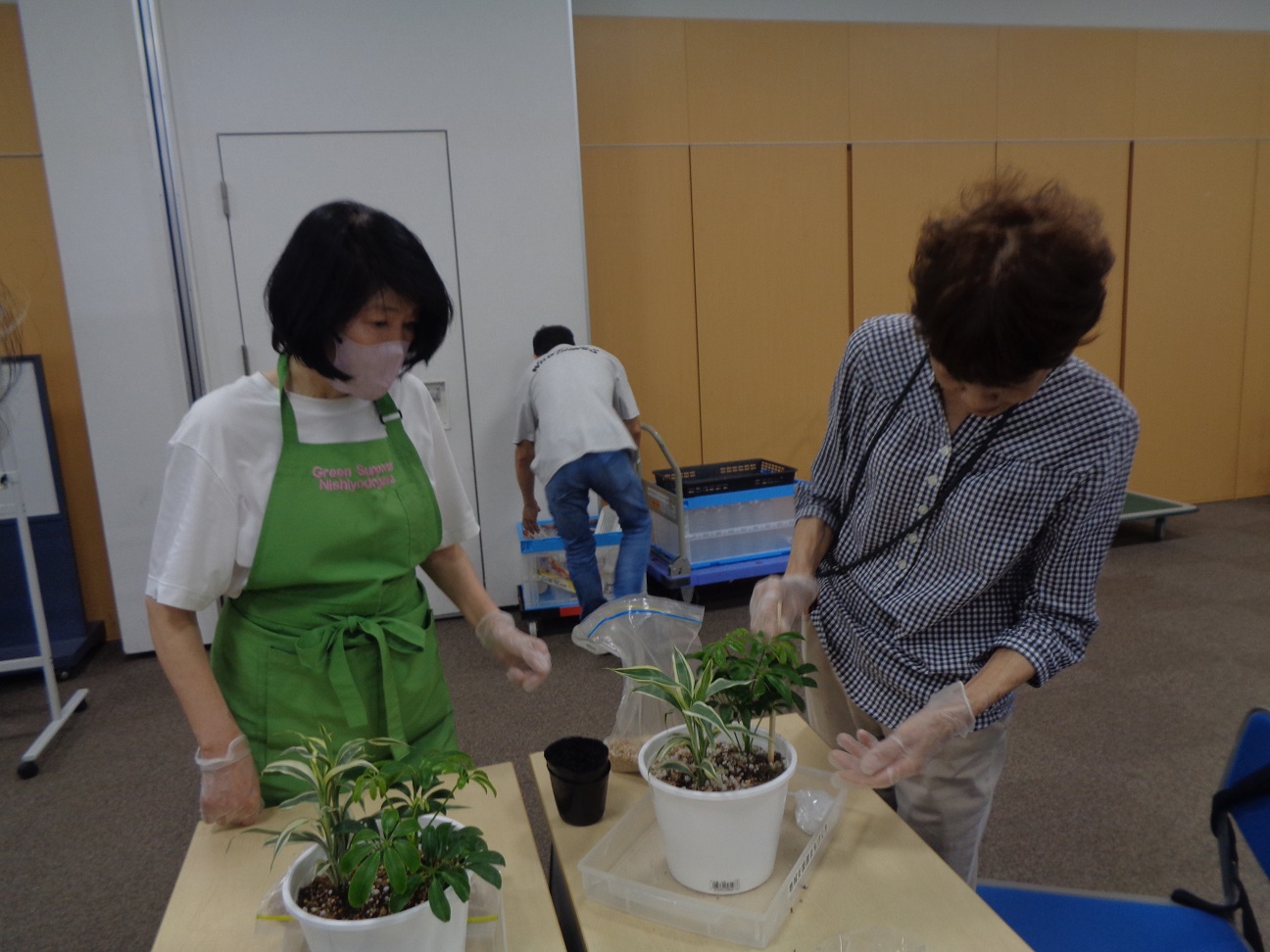 西淀川区緑化ボランティアさんが参加者のサポートをしながら観葉植物の育て方についての質問にも応えている様子