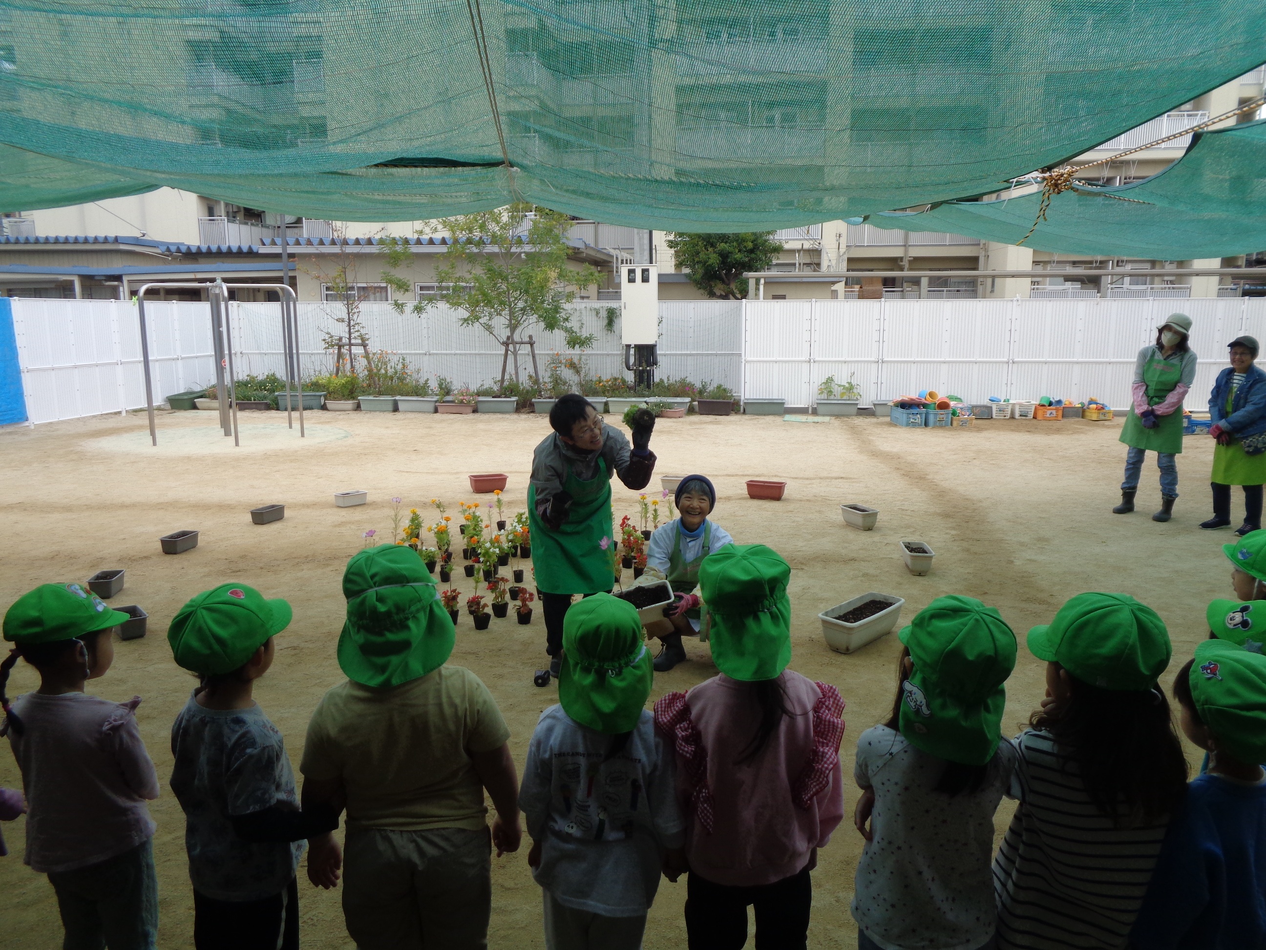 西淀川区緑化ボランティアさんが園児さんにお花の名前を説明している様子