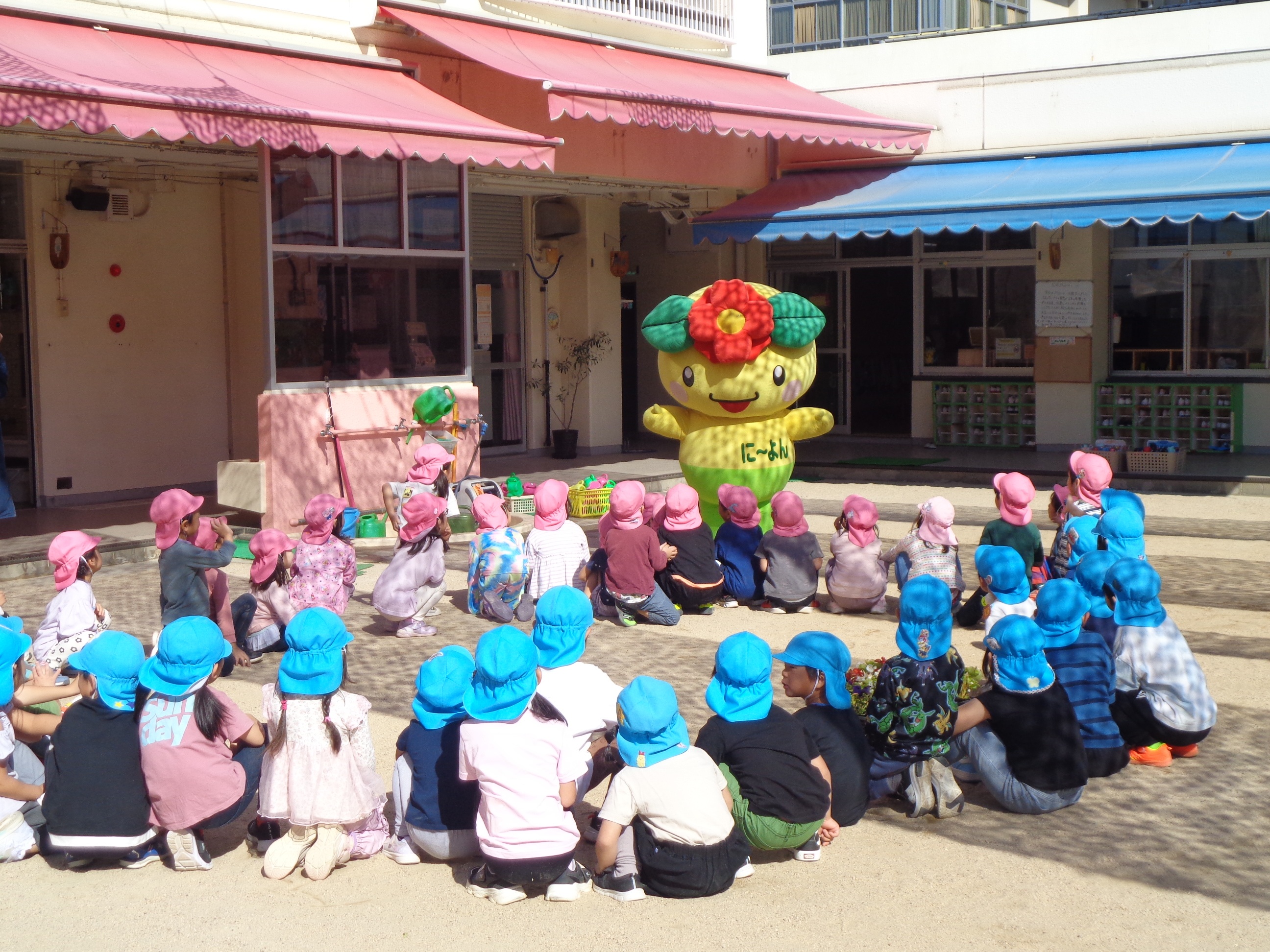 に～よんが登場し園児さんに近づいている様子