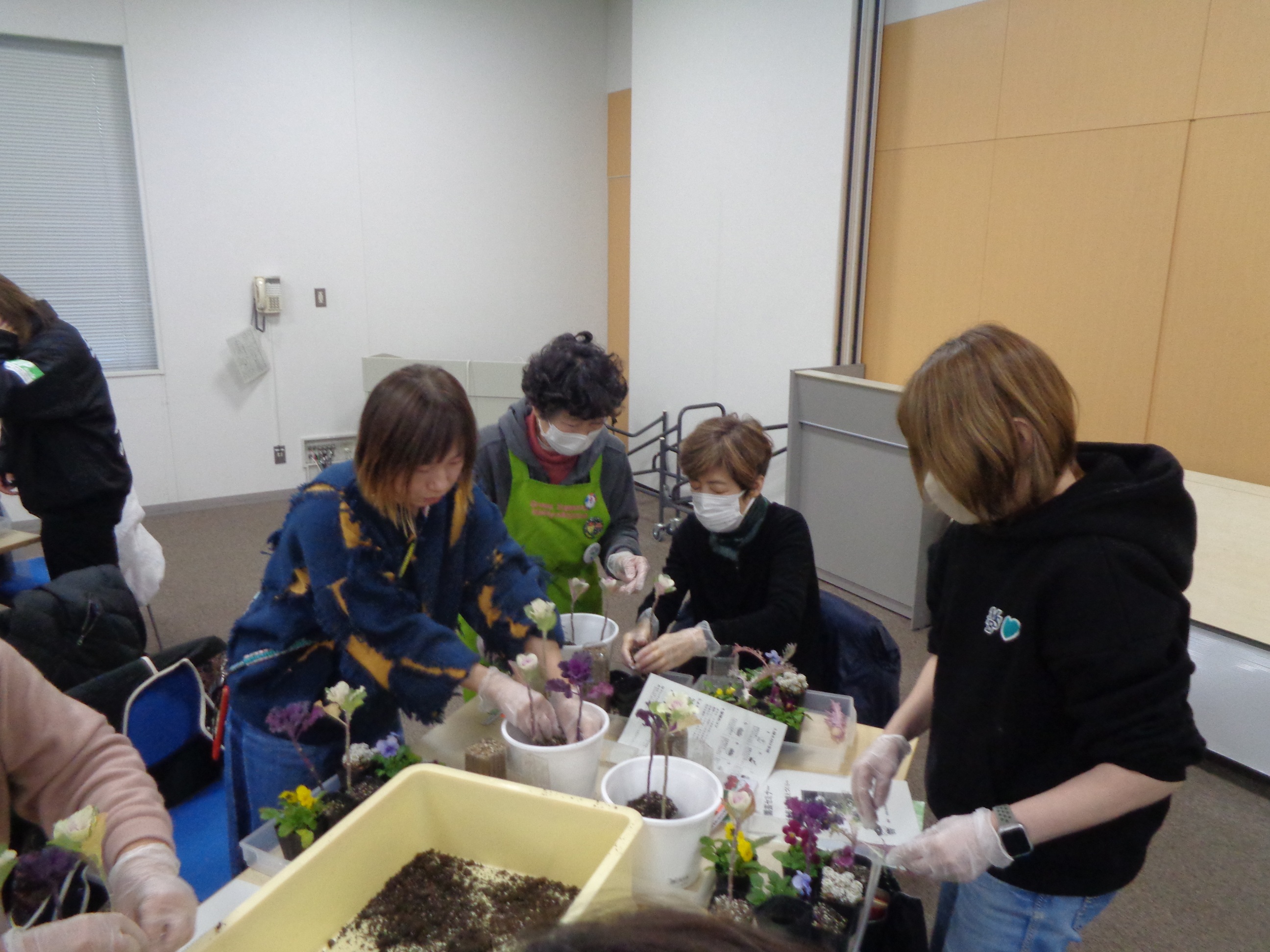 西淀川区緑化ボランティアさんが寄せ植え実習の補助をしている様子